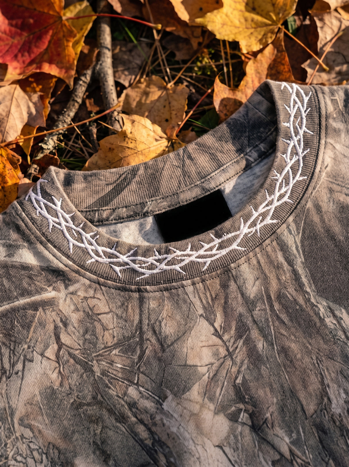 Crown of thorns embroidery around the tee collar